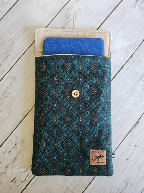 Pochette textile motif géométrique bleu-vert avec bouton, tablette bleue à l’intérieur, accessoire mode.