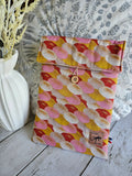Housse à livre ou liseuse en tissu coloré à motifs éventail, bouton en bois, posé sur bois clair