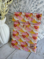 Housse à livre ou liseuse en tissu coloré à motifs éventail, bouton en bois, posé sur bois clair