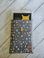 Housse à livre en tissu gris motifs pissenlit, bouton bois, sur fond bois clair