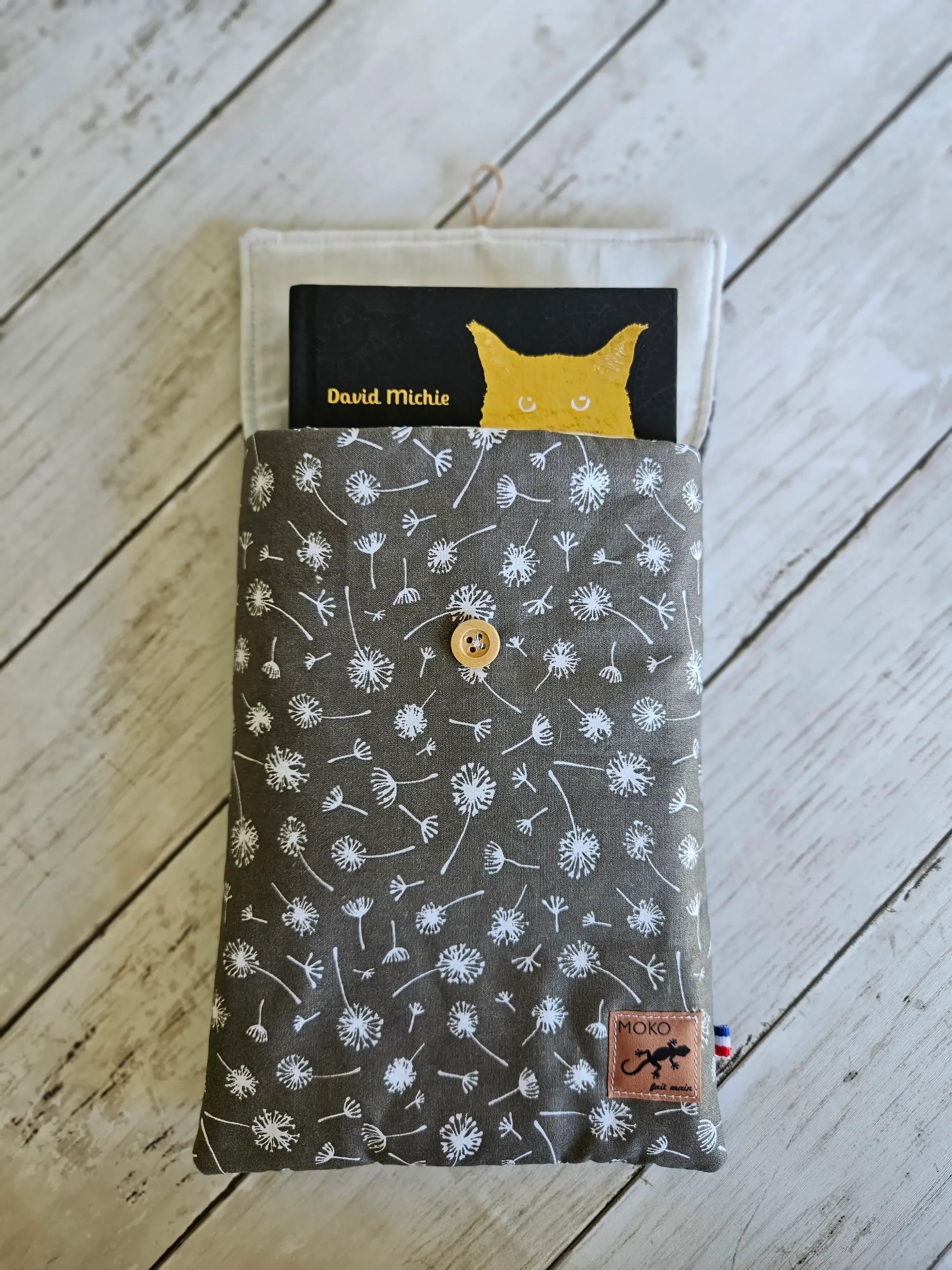 Housse à livre en tissu gris motifs pissenlit, bouton bois, sur fond bois clair