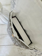 Housse à livre en tissu floral beige avec un livre à l'intérieur, bouton en bois visible.