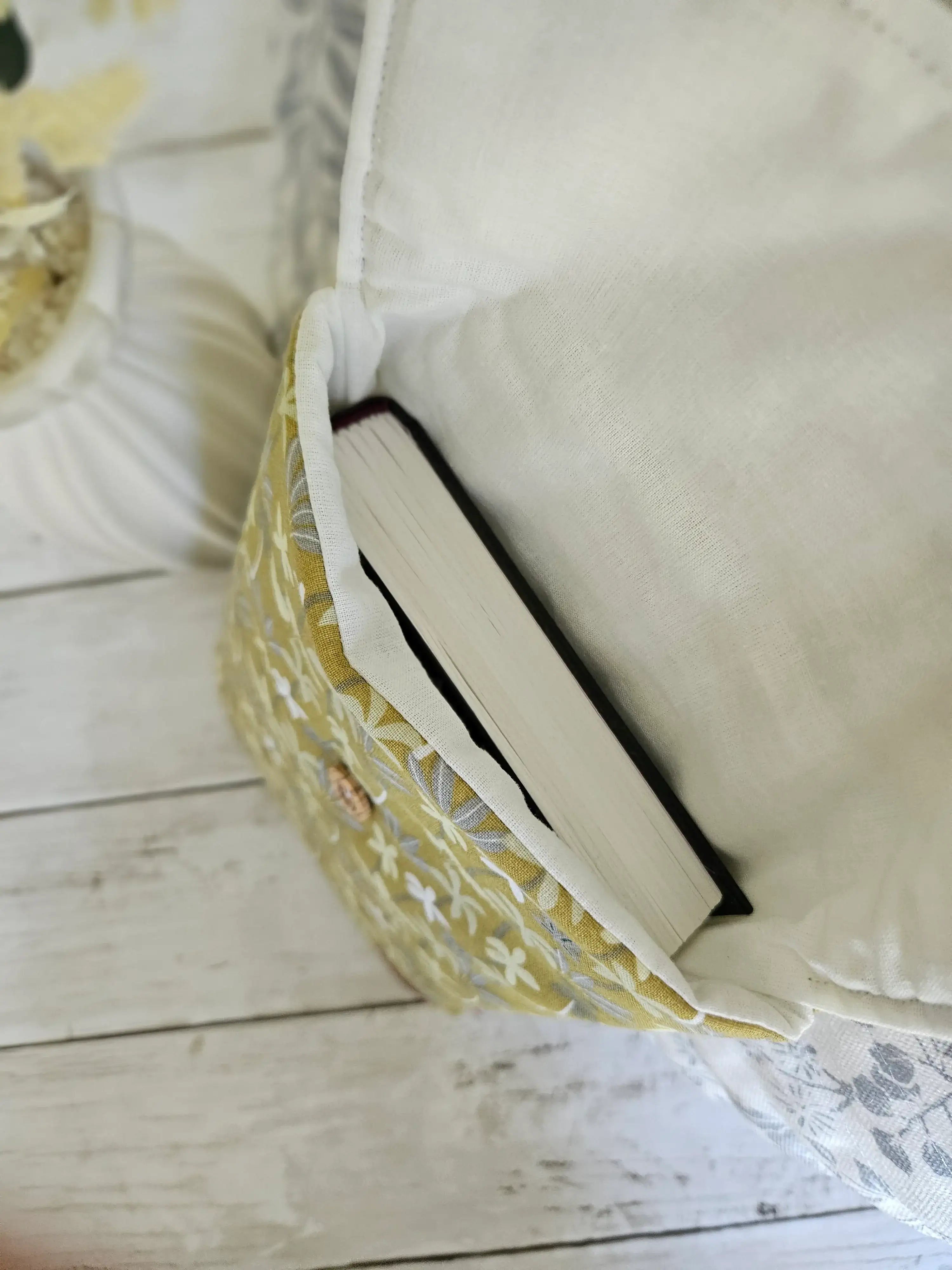 Housse à livre en tissu fleuri jaune et blanc avec un livre à l'intérieur, vue de dessus