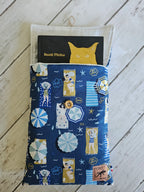 Housse à livre tissu bleu motifs plage, livre inséré, fond bois clair, accessoire lecture.