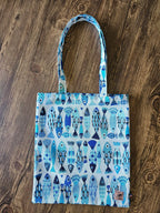 Sac cabas en tissu à motifs de poissons bleus, posé sur fond en bois, accessoire mode tendance.