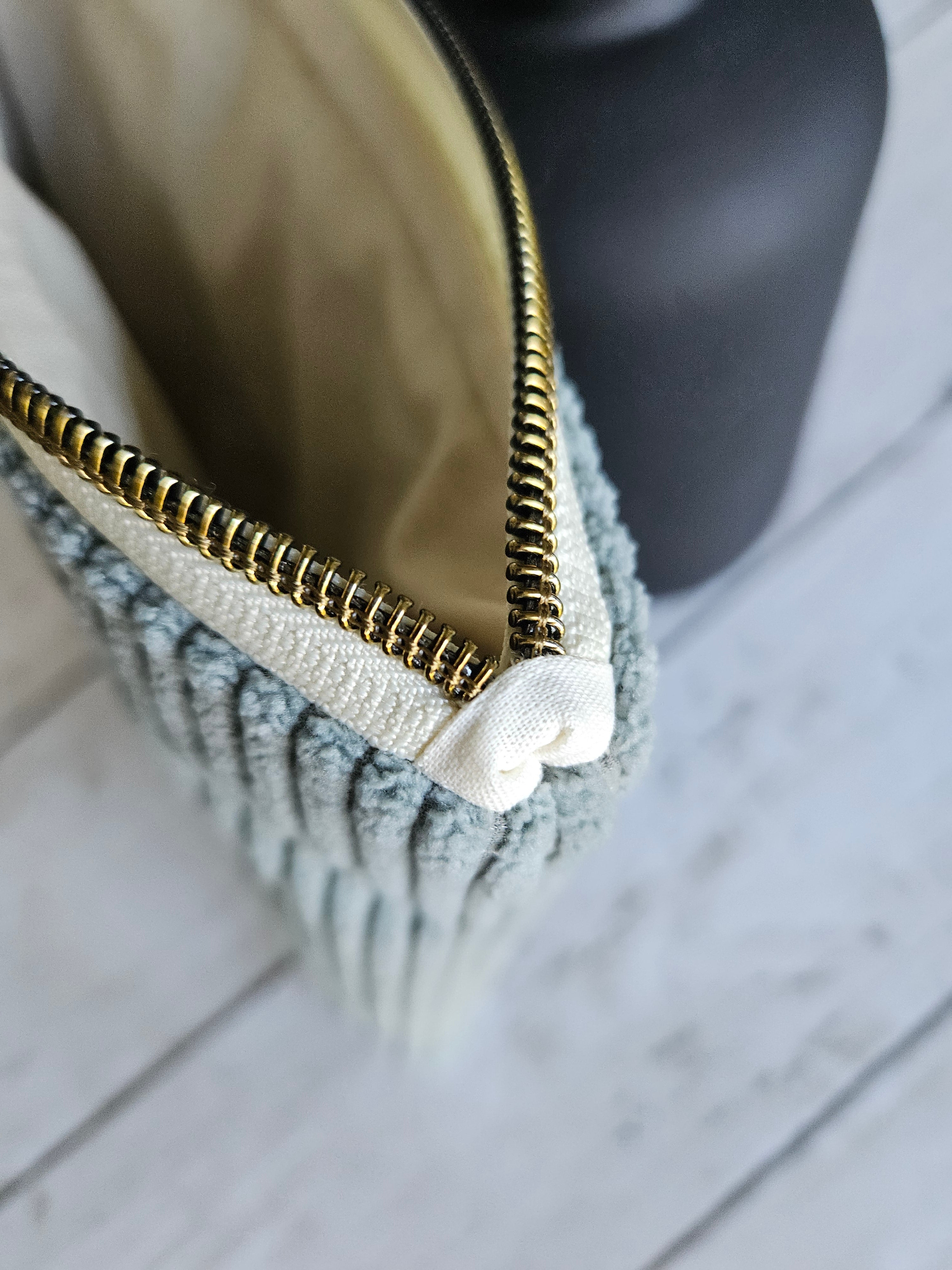 Trousse plate en velours vert d’eau avec fermeture éclair dorée, vue rapprochée