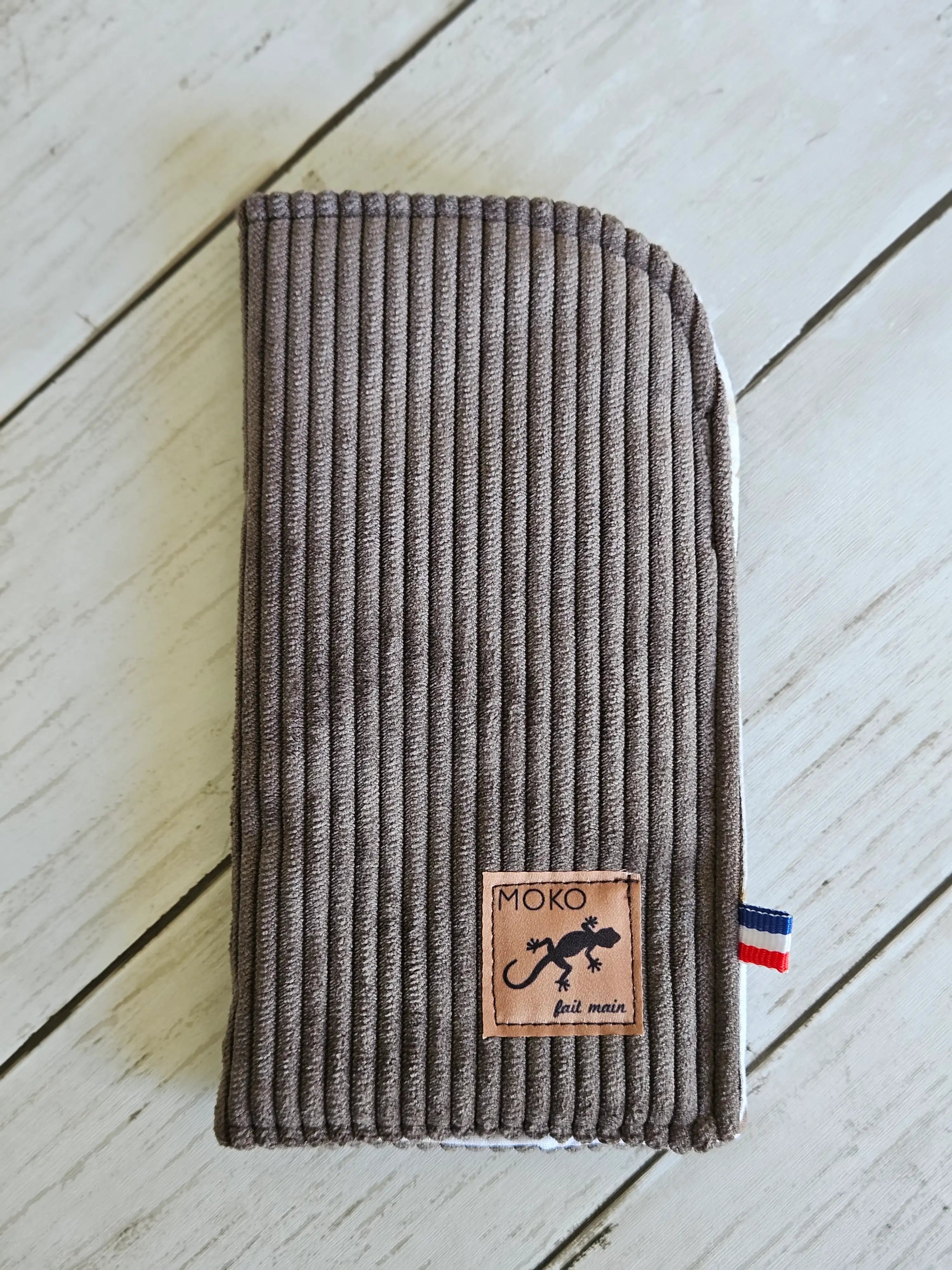 Étui à lunettes en velours côtelé marron, étiquette cousue, détail ruban tricolore.