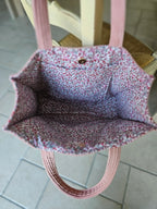Sac cabas en tissu rose, intérieur fleuri, posé sur une chaise, accessoire mode tendance