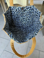 Intérieur d’un sac à main avec doublure tissu fleuri bleu et poignée ronde bois